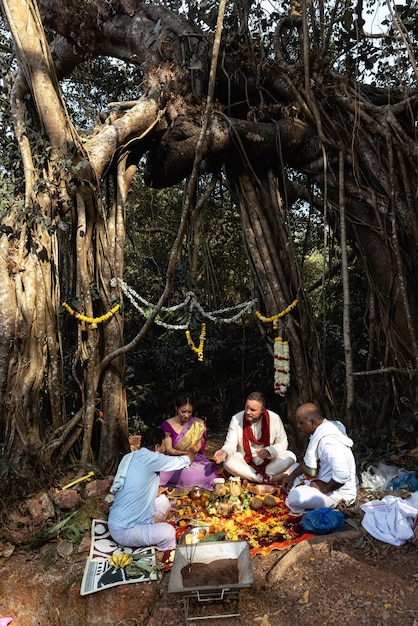 Grupa ludzi siedzi wokół drzewa z napisem mahabalipuram