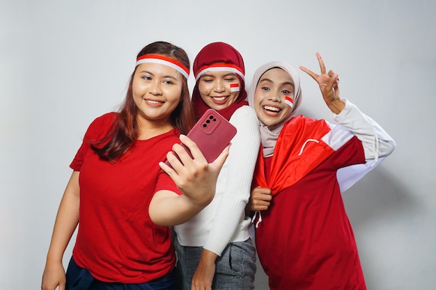 grupa ludzi używających czerwonych i białych atrybutów dla upamiętnienia dnia niepodległości Indonezji