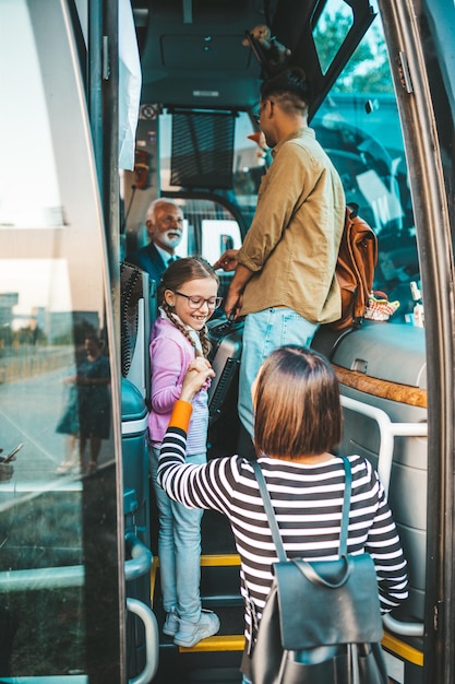 Grupa ludzi wsiadających do autobusu turystycznego. Koncepcja podróży, turystyki i wakacji.