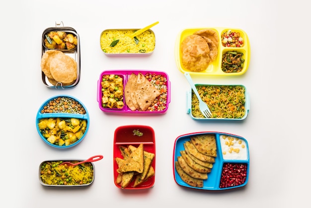 Grupa Lunch Box lub Tiffin dla indyjskich dzieci, pokazująca różnorodność lub wiele opcji lub kombinację zdrowej żywności dla dzieci uczęszczających do szkoły