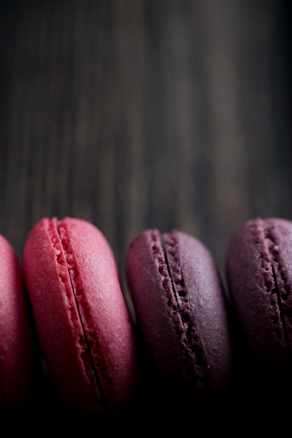 Grupa macarons robić truskawki, śmietanka, czekolada i jagody. Rustykalne zdjęcie.