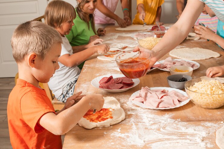 Grupa matek z dziećmi robi pizzę