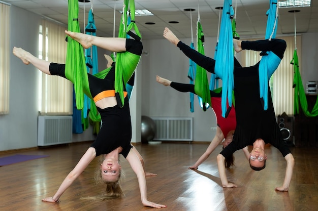 Grupa Młodych Kobiet Piękne Jogi Robi Aerial Jogi Praktyki W Hamakach W Klubie Fitness.