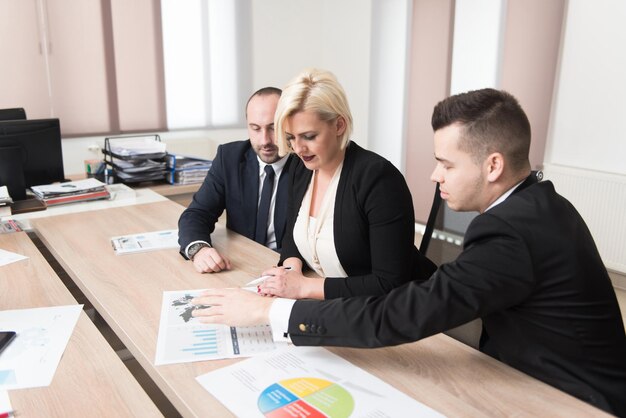 Grupa młodych ludzi biznesu spotyka się i pracuje w nowoczesnym, jasnym biurze w pomieszczeniu