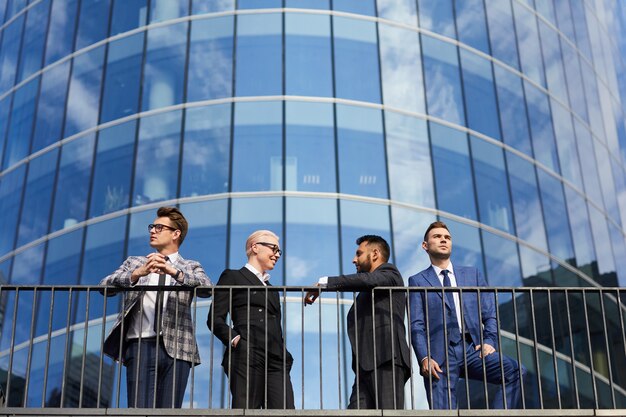 Zdjęcie grupa młodych ludzi biznesu stojących w mieście z nowoczesnym wieżowcem w tle