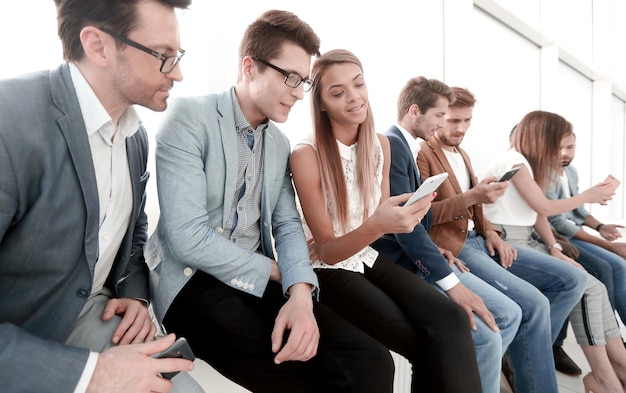 Zdjęcie grupa młodych ludzi korzysta ze swoich smartfonów koncepcja komunikacji