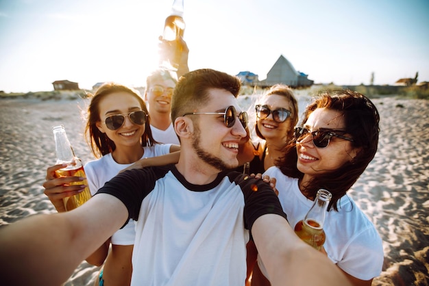 Grupa młodych przyjaciół biorących selfie i bawiących się na plaży Letnie wakacje relaksują się