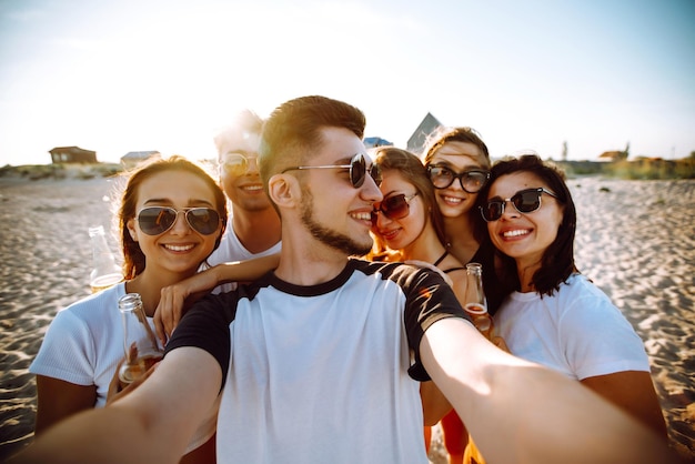 Grupa młodych przyjaciół biorących selfie i bawiących się na plaży Letnie wakacje relaksują się