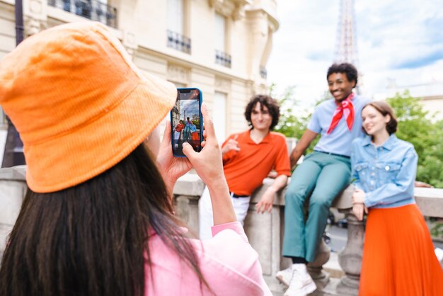 Zdjęcie grupa młodych szczęśliwych przyjaciół odwiedzających paryż i wieżę eiffla