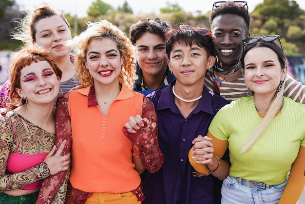 Grupa młodych wielorasowych ludzi noszących modne ubrania w stylu retro, uśmiechając się do kamery