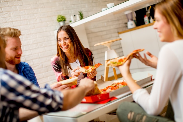 Grupa młodzi przyjaciele je pizzę