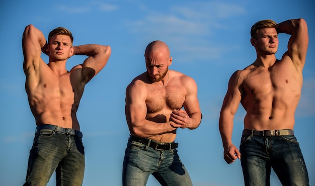 Grupa muskularnych mężczyzn na zewnątrz Atletyczni kulturyści Koncepcja sportu Muskularne ciało Muskularny oznacza potężny Trener siłowni Więcej siły, więcej mięśni Silni mężczyźni na tle błękitnego nieba Pokazuje biceps abs
