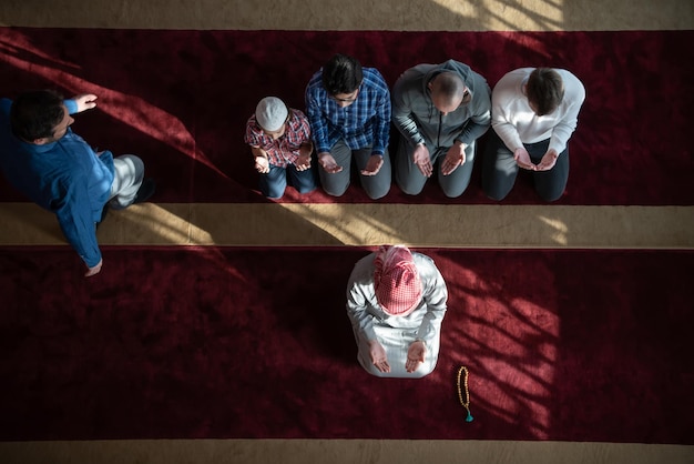 grupa muzułmanów modlących się namaz w meczecie.