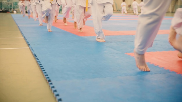 Grupa Nastolatków Karateka W Kimonie Biega Po Tatami Na Siłowni, Z Bliska