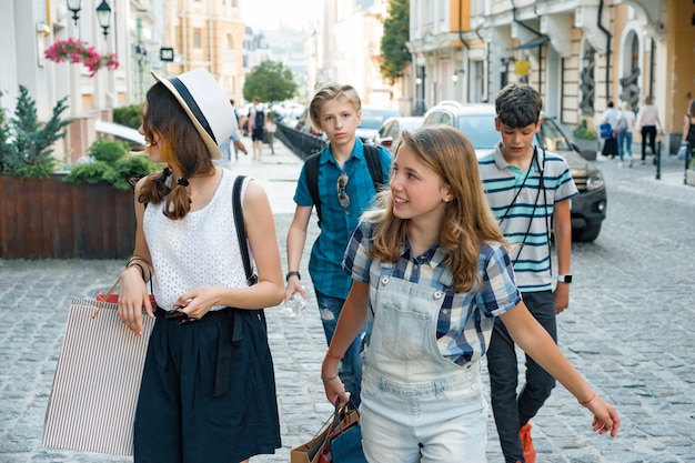 Grupa nastolatków z torby na zakupy na ulicy miasta.