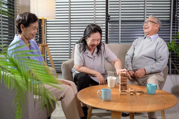 Grupa osób starszych lubi rozmawiać relaksując się z grą w starszym ośrodku opieki zdrowotnej