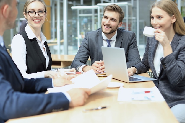 Grupa partnerów biznesowych omawiających pomysły i planujących pracę w biurze.