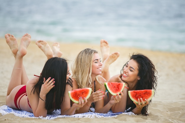 Grupa pięknych młodych dziewcząt na opalaniu na plaży