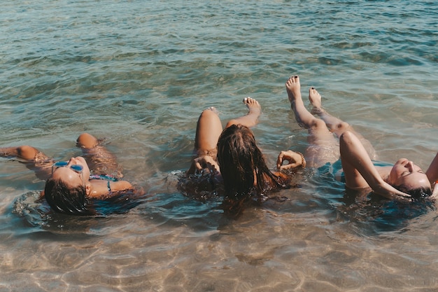 Grupa pięknych młodych kobiet odpoczywa na plaży.