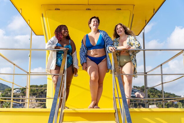 Grupa plus size kobiet w strojach kąpielowych na plaży