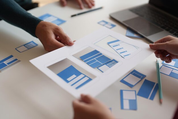 Grupa programistów ux i projektantów interfejsu użytkownika przeprowadza burzę mózgów na temat projektowania interfejsu aplikacji w nowoczesnym biurze Kreatywna agencja rozwoju cyfrowego