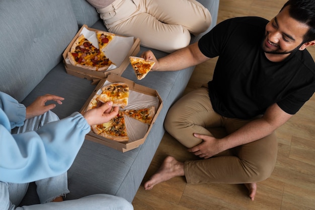 Zdjęcie grupa przyjaciele je pizzę wpólnie w domu