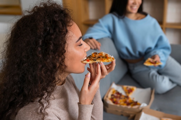 Zdjęcie grupa przyjaciele je pizzę wpólnie w domu