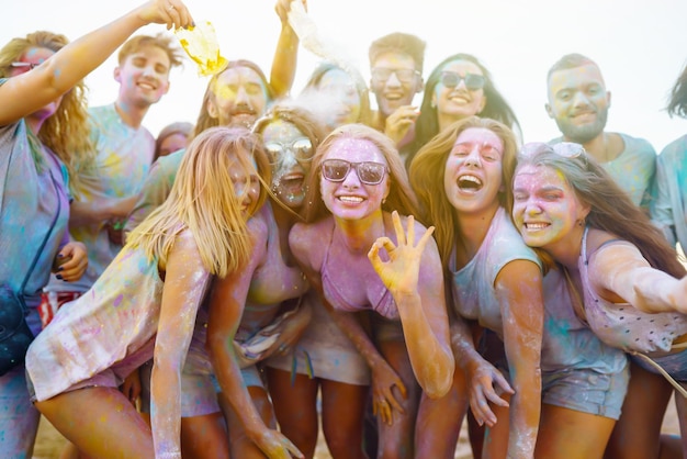 Grupa przyjaciół bawi się tańcem na festiwalu Holi Spring Beach Party Friendship Leisure Togetherness