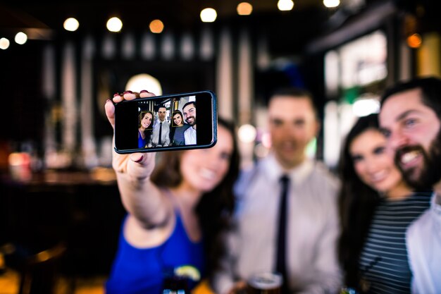 Grupa przyjaciół, biorąc selfie w barze