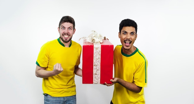 Grupa przyjaciół brazylijskich piłki nożnej z czerwonym prezentem na białym tle