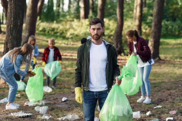 grupa przyjaciół, działaczy zbierających śmieci z parku