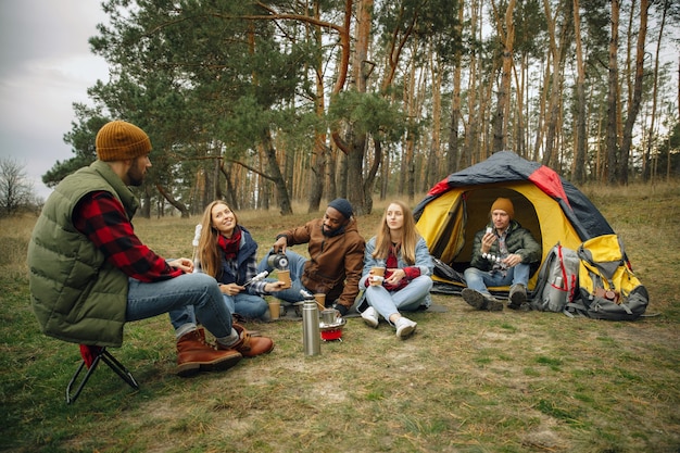 Grupa przyjaciół na kempingu lub wycieczce w jesienny dzień