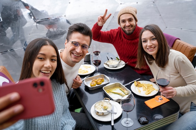Zdjęcie grupa przyjaciół robi selfie podczas wspólnego obiadu