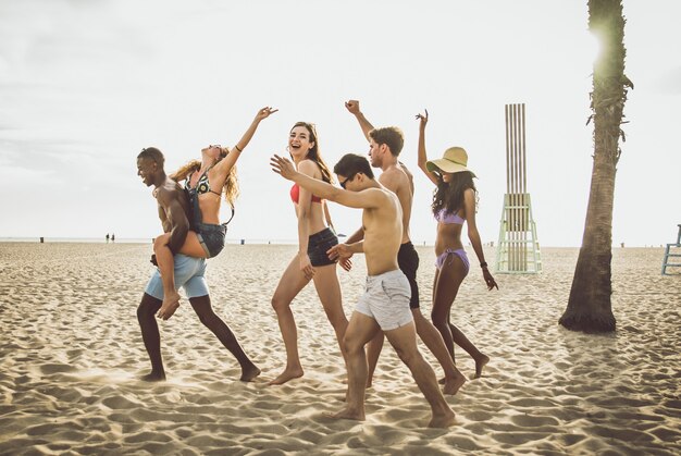 Grupa przyjaciół robi wielkie imprezy i gry na plaży