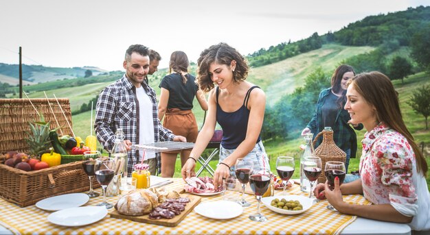 Grupa przyjaciół spędzających czas na pikniku i grillowaniu