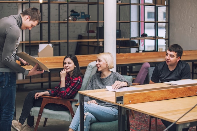 Grupa przyjaciół studentów robi i omawia kreatywne pomysły na strychu