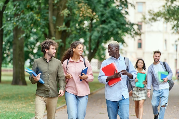 Grupa przyjaciół studentów spacerujących po parku