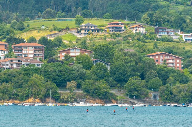 Grupa przyjaciół uprawiająca paddle surfing na morzu w Urdaibai, rezerwacie biosfery Bizkaia obok Mundaki. kraj Basków