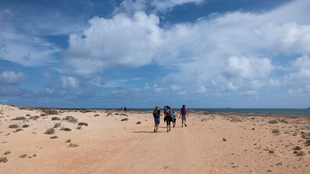Grupa przyjaciół wędrująca po dziewiczych plażach na wyspie La Graciosa na Wyspach Kanaryjskich.