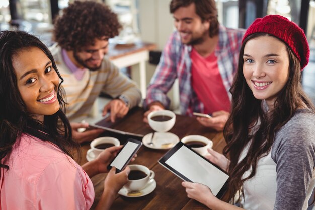 Grupa przyjaciół za pomocą cyfrowego tabletu i telefonu komórkowego