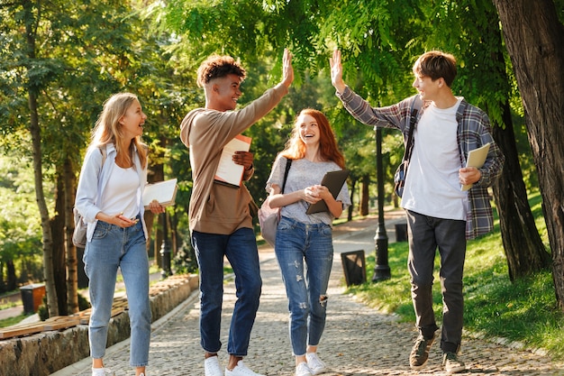 Grupa roześmianych studentów spacerujących po kampusie