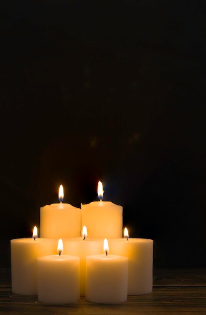 Grupa siedmiu płonących świec ze szczegółami świątecznymi ze złotymi tonami i czarnym tłem. Chrystus