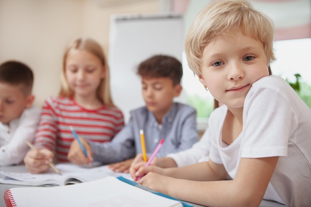 Zdjęcie grupa śliczne małe dzieci rysunek razem w klasie sztuki