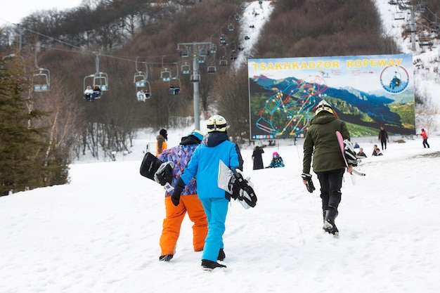 Zdjęcie grupa snowboardzystów wspina się po śnieżnym zboczu