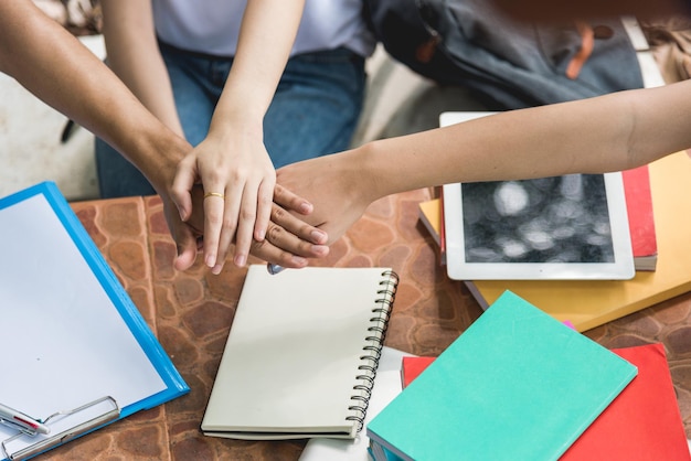 Zdjęcie grupa studentów kolegium kładących ręce na sobie, pokazujących jedność pracy zespołowej