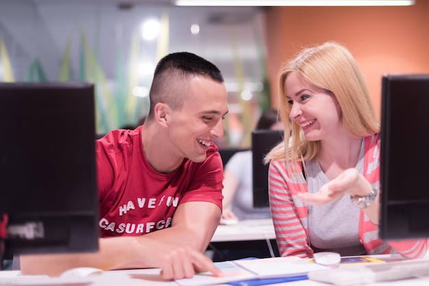 grupa studentów technologii w klasie szkolnej w laboratorium komputerowym pracuje nad