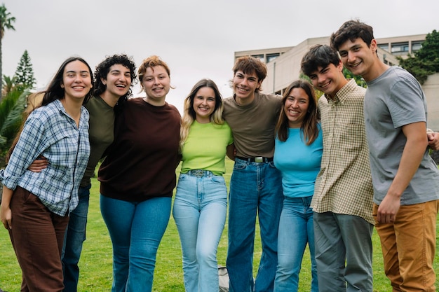 Grupa studentów uśmiechających się do kampusu kamery