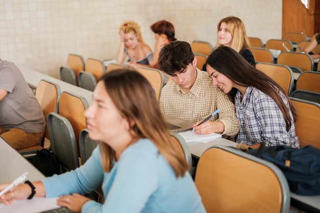 Grupa studentów w klasie, podczas gdy nauczyciel prowadzi lekcję