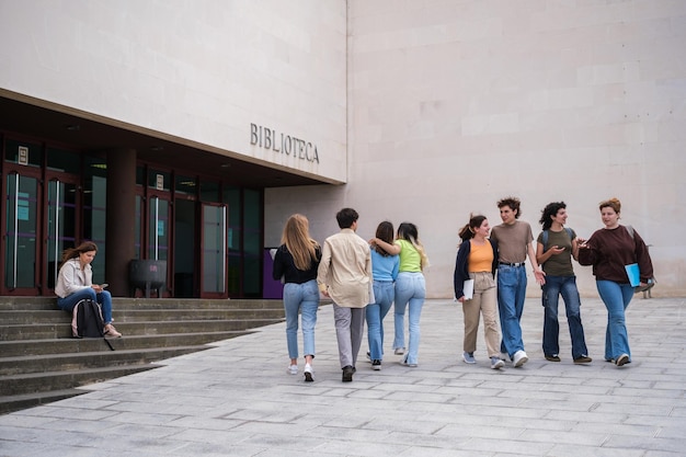 Grupa studentów wchodzących i opuszczających uniwersytet wraz z grupami przyjaciół Concept Studies College Life Youth