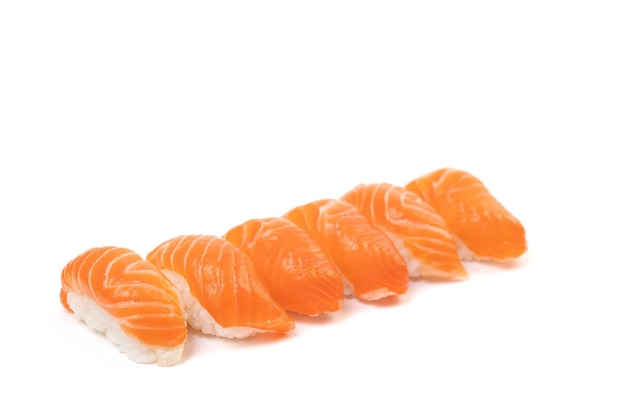 Grupa Sushi Łososia w rzędzie na białym tle To tradycyjne japońskie jedzenie jedzone między surowym świeżym łososiem i ryżem